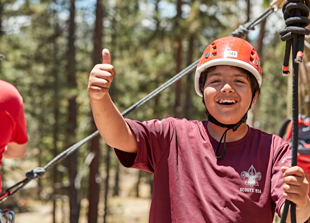 Scouts BSA youth giving a thumbs up while rock climbing