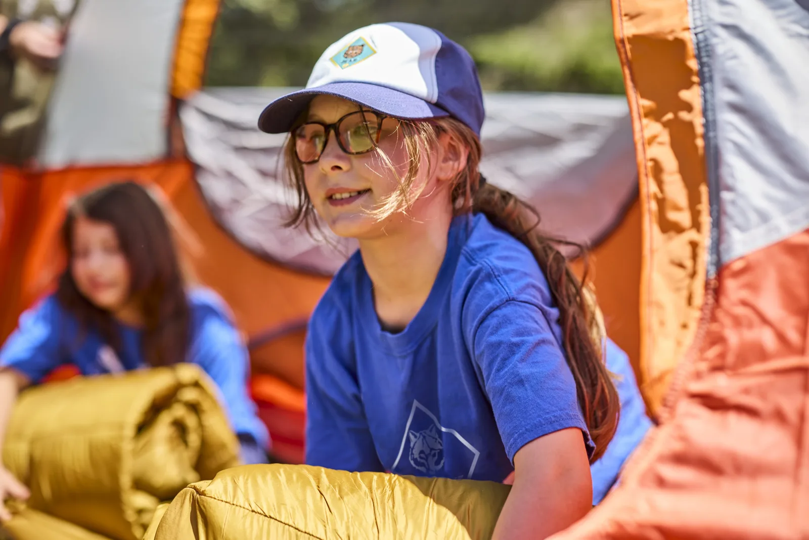 Cub Scout girl setting up a tent at a campsite