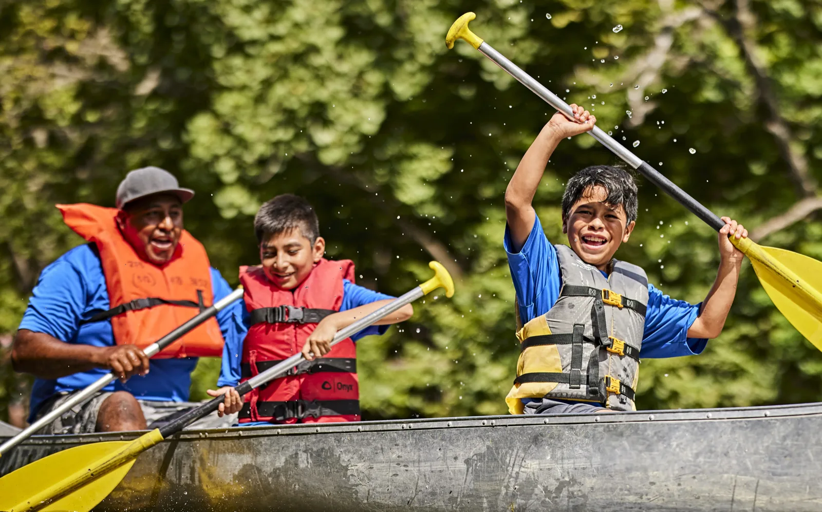 Scout family paddling a canoe together on a river